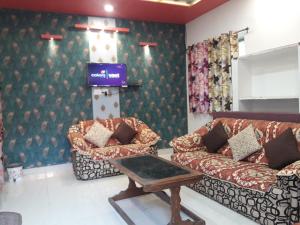 uma sala de estar com dois sofás e uma televisão em Hotel RAJVIHAR em Pachmarhī