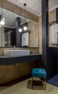 
a bathroom with a sink and a mirror at Hotel Don Curro in Málaga

