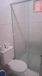 uma casa de banho com um WC e uma cabina de duche em vidro. em Hotel Pio em Teresina