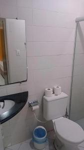 uma casa de banho com um WC, um lavatório e um espelho. em Hotel Pio em Teresina