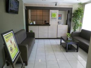 a living room with couches and a table and a counter at RedDoorz At Jalan Sriwijaya Semarang in Semarang