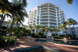 a large apartment building with a swimming pool and palm trees at Mariners North Holiday Apartments in Townsville