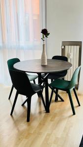 uma mesa com cadeiras e um vaso com uma flor em Ale’s House em Veneza-Lido