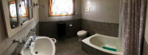 uma casa de banho com uma banheira, um WC e um lavatório. em Hospedaje Amilcar em Esquel