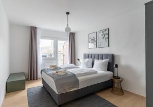 a white bedroom with a bed and a window at Limehome Magdeburg Breiter Weg in Magdeburg