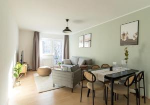 a living room with a table and a couch at Limehome Magdeburg Breiter Weg in Magdeburg