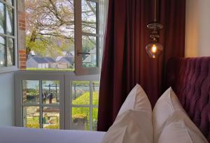 een slaapkamer met een bed en een groot raam bij Hôtel Ginkgo - SPA Biloba in Quimper