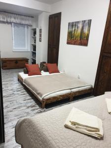 a bedroom with two beds and a painting on the wall at Apartmán Dávid - AD Magura in Donovaly