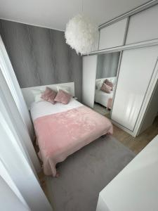奧西耶克的住宿－La bella casa，卧室配有粉红色的床和镜子