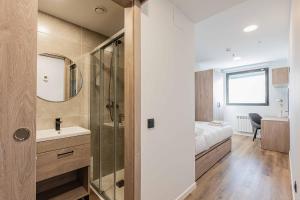 bagno con letto, lavandino e specchio di Micampus Santander a Santander
