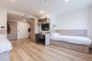 a bedroom with two beds and a desk in it at Micampus Santander in Santander