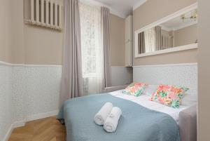a bedroom with a bed with towels on it at Apartament przy Placu Zamkowym by Renters in Warsaw