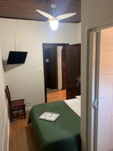 1 dormitorio con 1 cama verde y ventilador de techo en Hotel Real Paulista en São Paulo