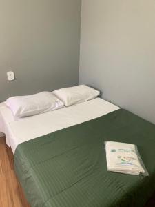 a bed with a green and white blanket on it at Hotel Real Paulista in Sao Paulo