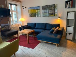 uma sala de estar com um sofá azul e uma mesa em Nice flat and area em Copenhaga