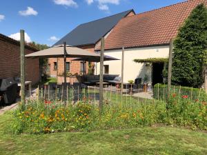 a house with a garden with flowers in the yard at Vakantiehuis wellness Oase in Londerzeel