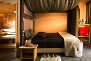 a bedroom with a large bed and a table at Vakantiehuis wellness Oase in Londerzeel