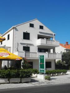 a large white building with a sign in front of it at Apartments Logos in Cavtat