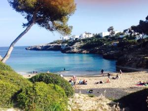 eine Gruppe von Menschen an einem Strand in der Nähe des Ozeans in der Unterkunft Cala Ferrera HOME&ME in Felanitx