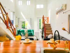 a room with a wooden table and a living room at Sunsets At Tiffany's in Treasure Beach +28 photos