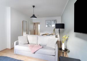 - un salon avec un canapé blanc et des oreillers roses dans l'établissement limehome Magdeburg Breiter Weg, à Magdebourg