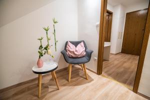 una silla y una mesa con una almohada rosa. en Guesthouse Leski Dvor en Lesce