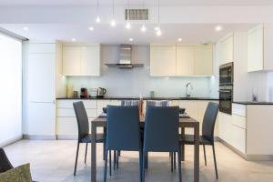 a kitchen with a dining room table and chairs at SERRENDY Apartment with swimming pool in Cannes