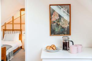 um quarto com uma cama e uma mesa com uma tigela de pão em Polly's Yard Dennington Suffolk em Dennington