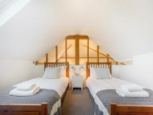 Duas camas individuais no quarto do sótão de uma casa em Polly's Yard Dennington Suffolk em Dennington