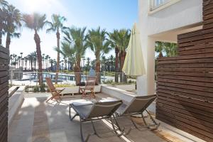 a patio with chairs and an umbrella and palm trees at Seven Seas Hotel Blue - Ultra All Inclusive & Kids Concept in Side