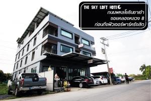 a building with cars parked in front of it at The Sky Loft Hotel in Pathum Thani