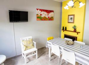 a dining room with a table and chairs and a tv at Departamento Moreno 2 in Santa Rosa