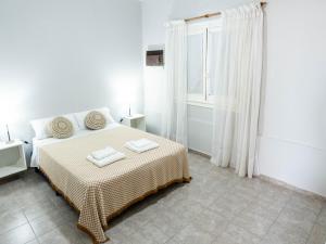 a white bedroom with a bed and a window at Departamento Moreno 2 in Santa Rosa
