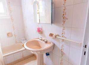 a bathroom with a sink and a tub and a mirror at Departamento Moreno 2 in Santa Rosa +6 photos