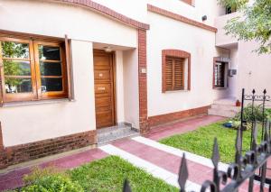 a house with a wooden door and a yard at Departamento Moreno 2 in Santa Rosa