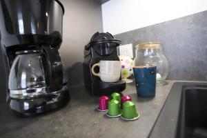 eine Küchentheke mit Kaffeemaschine und Kaffeekanne in der Unterkunft Le Jardin de Boubioz in Sévrier