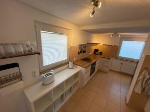 a kitchen with white cabinets and a large window at Ferienwohnung di Simoni in Bad Laasphe