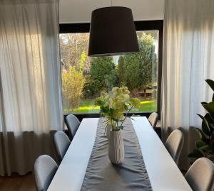 a white table with a vase of flowers on it at Ferienwohnung di Simoni in Bad Laasphe