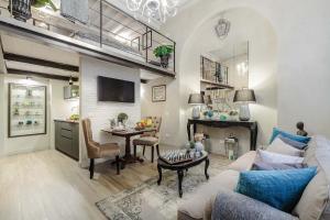 ein Wohnzimmer mit einem Sofa und einem Tisch in der Unterkunft Paolo Guinigi, Elegant Apartment Suite, Masterful Interior inside the Walls of Lucca in Lucca