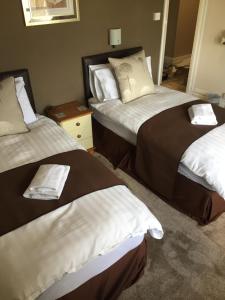 a hotel room with two beds with towels on them at Woodthorpe Hotel in Skegness