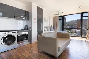 sala de estar con sofá y lavadora en Urban Oasis At The Four Seasons, en Ciudad del Cabo