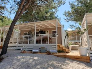 a house with a porch with chairs and a tree at Seamoon home in Jezera