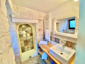 a bathroom with a sink and a shower at Trulli Moon in Alberobello