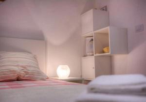 a white bedroom with a bed and a lamp at Two Friends Dubrovnik Palace in Dubrovnik