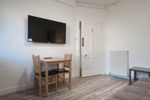 a room with a table and a television on a wall at Hutch 2 Bed Apart in Aberdeen