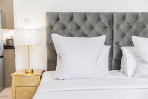 a bedroom with a white bed with a gray headboard at Elizabeth Flat 5 - By Luxury Apartments in Cheltenham