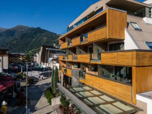 un immeuble d'appartements avec des balcons en bois et une rue dans l'établissement LEDERER Boutique Hotel, à Kaprun