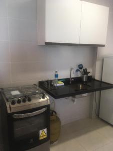 a small kitchen with a stove and a sink at Praia Bela, vista mar. Novo! in Pitimbu