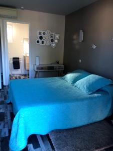 een groot blauw bed met een blauw dekbed in een slaapkamer bij Lagalerne in Neuville-du-Poitou
