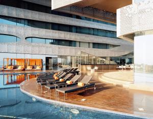 a large building with a pool and a group of chairs at The Park Hyderabad, Banjara Hills near Hussain Sagar Lake in Hyderabad